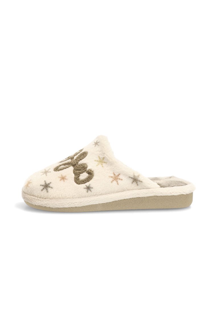 Zapatilla de color crema hecha de un material suave y aterciopelado. Presenta estrellas bordadas y un diseño decorativo. Plantilla acolchada y suela plana.