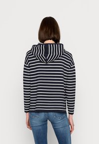 Marineblauer und weißer gestreifter Pullover mit Kapuze, langen Ärmeln und einem lässigen Schnitt. Der Stoff wirkt weich und leicht strukturiert.