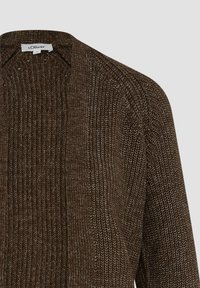 Brauner gestrickter Cardigan mit offenem Frontdesign. Besitzt ein strukturiertes Muster und eine lockere Passform. Etikett am Ausschnitt sichtbar.