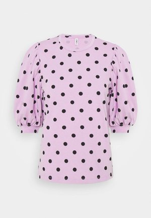 Camisa corta de manga corta en púrpura con lunares negros, mangas abullonadas y cuello redondo. Tela de algodón con una textura suave.