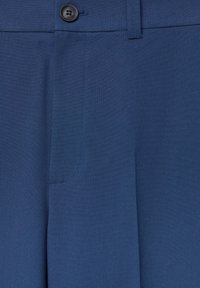 Pantalon bleu marine en tissu doux, avec un seul bouton noir et une poche avant. Texture lisse avec des détails de couture soignés.