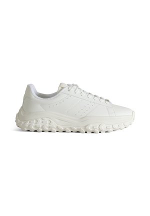 White low-top sneaker with chunky textured sole, lace-up front, and subtle perforated side detailing.