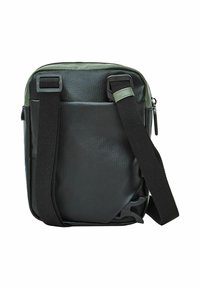 Bolso bandolera de tela negra con textura, correa ajustable, cierre de cremallera y un bolsillo frontal. Presenta un diseño suave y minimalista.