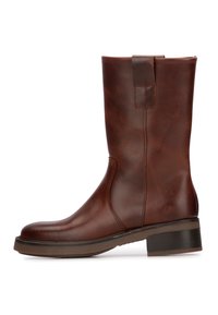 Botas de tobillo de cuero marrón con una textura lisa, punta redondeada, paneles elásticos laterales y un tacón bajo apilado.