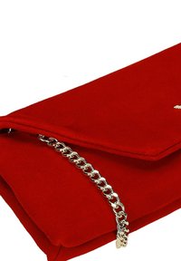 Červená látková kabelka s klopou, vybavená stříbrným řetízkovým popruhem a hladkou texturou. Ozdobena jemným logem.