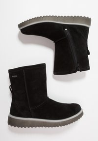 Stivaletti neri in suede fino alla caviglia con suola in gomma piatta e scanalata e zip laterale. Presentano una linguetta sul tallone per indossarli facilmente.