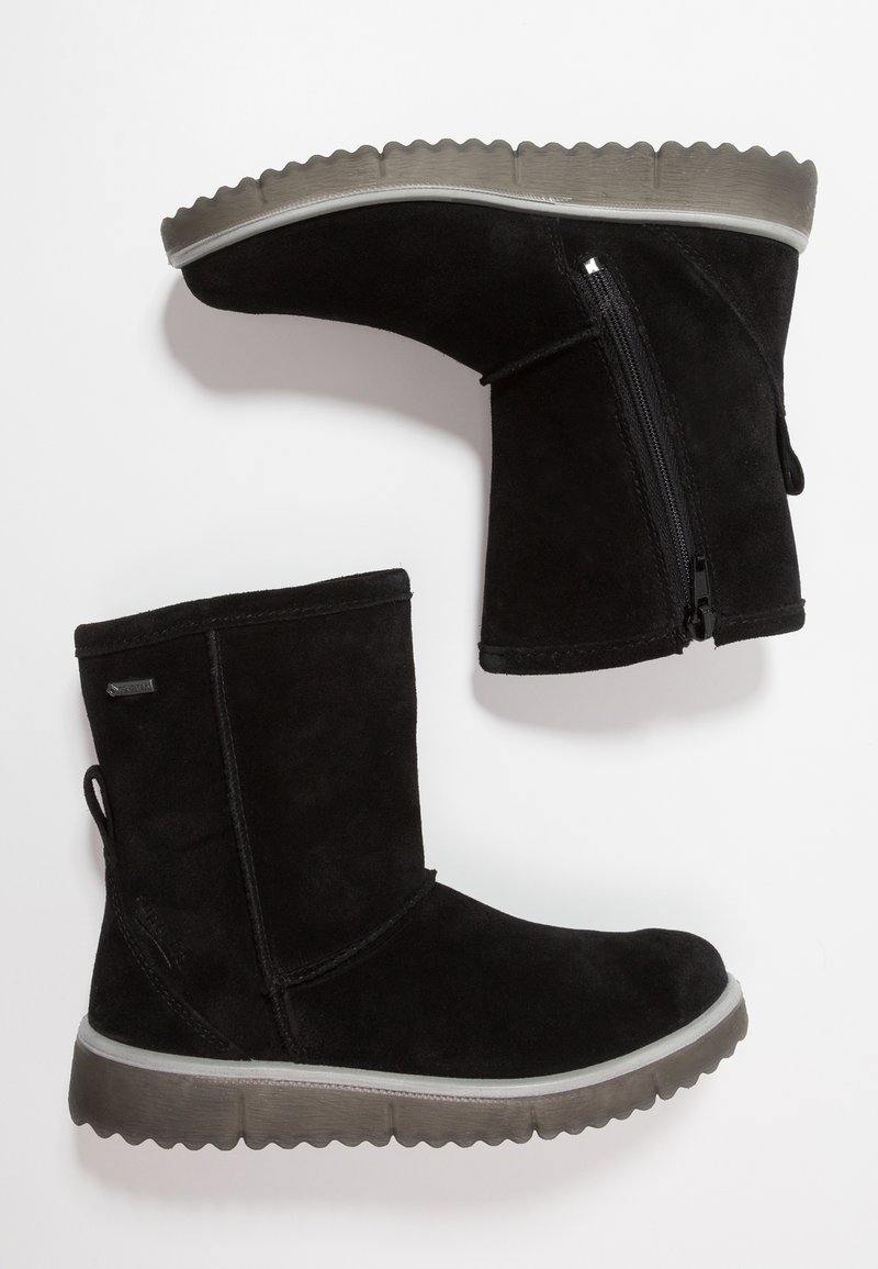 Stivaletti neri in suede fino alla caviglia con suola in gomma piatta e scanalata e zip laterale. Presentano una linguetta sul tallone per indossarli facilmente.