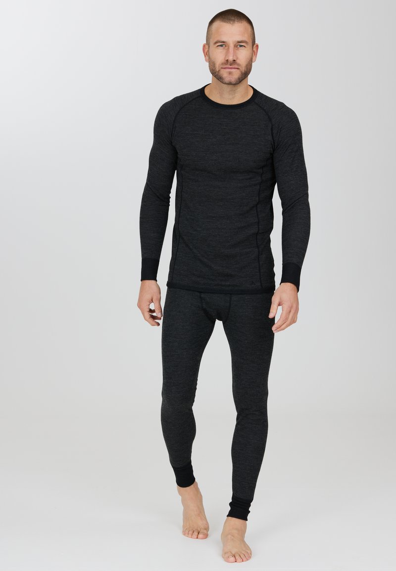 Svart termisk långärmad topp med raglanärmar och matchande åtsittande byxor. Har elastiska mudd och en slät, strukturerad yta.