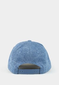 Blue denim baseball cap with a textured fabric, adjustable plastic snapback, and ventilation eyelets on the back.