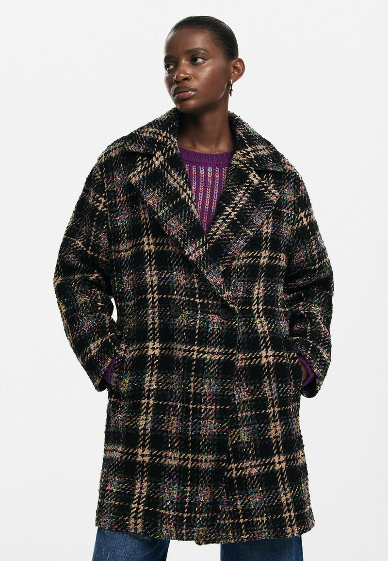 Double-breasted plaid coat featuring black, beige, and multicolor threads. Made from textured fabric with large notched collar and side pockets.