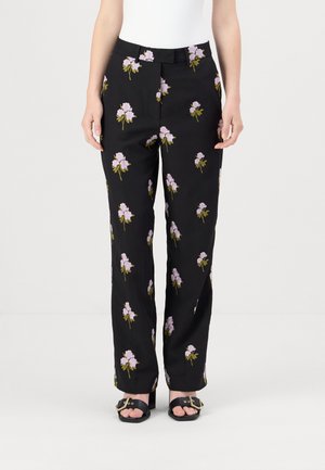 Black trousers featuring a floral pattern with purple flowers and green stems. Smooth fabric, straight-leg design, with a waistband and belt loops.