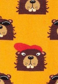 Calcetines de punto con un fondo amarillo brillante que presenta caras de osos marrones en estilo de dibujos animados. Algunos osos llevan accesorios como un sombrero rojo o gafas de sol.