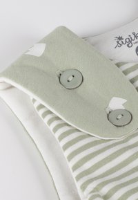 Grünes Hemd mit strukturiertem, einfarbigem Stoff und innen weiß gestreift. Verfügt über zwei hellgraue Knöpfe und ein Logolabel.