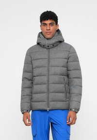 Grå puffjacka med huva, med en quiltad design, dragkedjestängning, två sidofickor och tryckknappar på kragen.