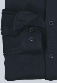 Dunkelblauer Strickpullover mit einem gefalteten Design und Knopfverschlüssen sowie einer strukturierten Stoffoberfläche. Verfügt über passende Knöpfe und einen Kragen.