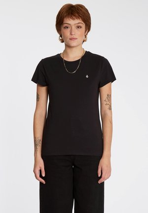 T-shirt en coton noir à manches courtes, col rond et petit logo sur la poitrine gauche. Associé à un pantalon noir taille haute.