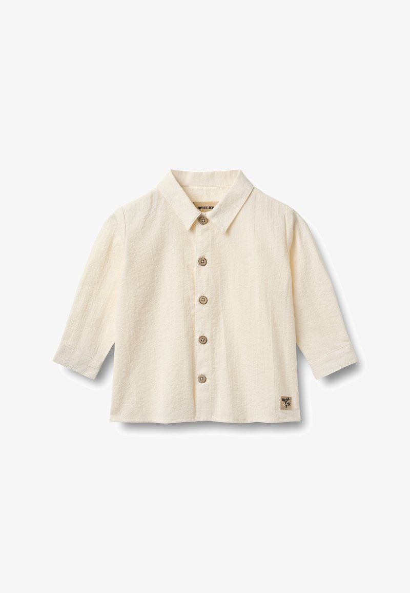 Chemise boutonnée couleur crème avec col à revers, manches trois-quarts, tissu texturé et boutons en bois. Patch logo sur l'ourlet inférieur.