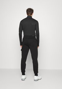 Puma CARGO PANTS - Pantalones deportivos - schwarz