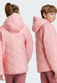 Chaqueta acolchada rosa con capucha, que presenta un patrón de costura diagonal. Incluye puños elásticos y una textura suave y lisa.