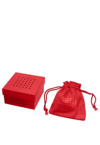 Scatola regalo rossa con texture e coperchio perforato, accompagnata da un sacchetto con coulisse rosso abbinato, entrambi con il logo in rilievo "DIESEL".