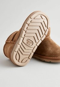 Bottes à mi-mollet en suède marron avec une base texturée et une semelle en caoutchouc crème crantée. Taille UK 6 indiquée sur la semelle.