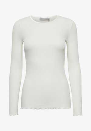 Biała bluzka z długim rękawem, wykonana z prążkowanej tkaniny, z okrągłym dekoltem oraz falbaniastymi krawędziami przy mankietach i u dołu. Gładka faktura, dopasowany krój.
