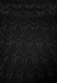 Tessuto nero con un motivo a diamante testurizzato e intricato. Il design è caratterizzato da cuciture in rilievo che creano profondità e interesse visivo.