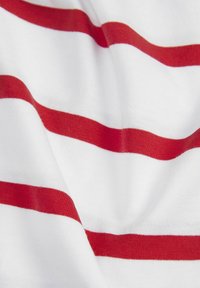 Tejido blanco con rayas rojas horizontales, que presenta una textura suave. Las rayas varían en ancho, creando un patrón simple.