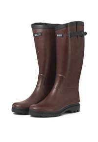 Une paire de grandes bottes en caoutchouc marron avec des semelles noires et des sangles latérales ajustables, étiquetée "AIGLE" sur le haut de la tige avant.