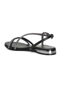 Sandal nero con cinturini incrociati adornati da borchie argentate. Presenta un tacco basso con un accento metallico e una cinghia alla caviglia con fibbia.