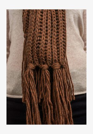 Hnědý pletený šátek z tlusté, strukturované příze. Má splétané konce s dlouhými třásněmi. Nosit se přes lehký svetr.