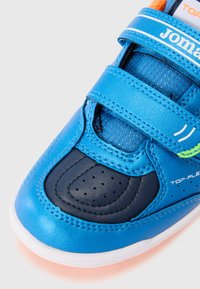 Zapatilla deportiva azul con acentos en azul marino, que cuenta con dos correas de Velcro ajustables, puntera perforada y lengüeta de tela texturizada.