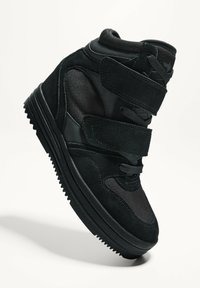 Sneaker alte nere con un mix di materiali in suede e rete, cinturini in velcro e una suola in gomma testurizzata.