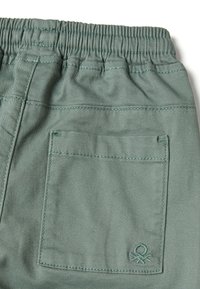 Grüne Baumwollhose mit elastischem Bund, versehen mit einer Gesäßtasche mit abgesteppten Details und einem kleinen Logoemblem.