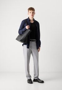 Bolsa tote de cuero negro, camisa ligera azul marino, top de tirantes negro acanalado, pantalones grises, zapatos negros; textura suave, diseño simple, colores neutros.