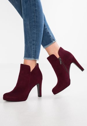 Bordowe zamszowe botki za kostkę z bocznym zamkiem, w szpic, na 10 cm szpilce, z wycięciami wzdłuż kostki.