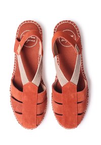 Sandalias de ante rojo con un diseño de corte, correas elásticas cruzadas y una suela cosida. Tejido texturizado y detalles de costura contrastantes.