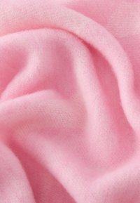 Miękka różowa tkanina o gładkiej fakturze z subtelnymi odcieniami, prezentująca lekkość i ciepło. Nadaje się do odzieży lub akcesoriów.