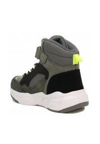 Basket haute en suède gris et noir avec des panneaux en mesh, dotée d'une semelle blanche et d'un accent vert fluo au talon. Sangle ajustable.
