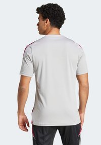 Light gray athletic shirt featuring short sleeves and maroon accents on the shoulders, made from a smooth, breathable fabric.