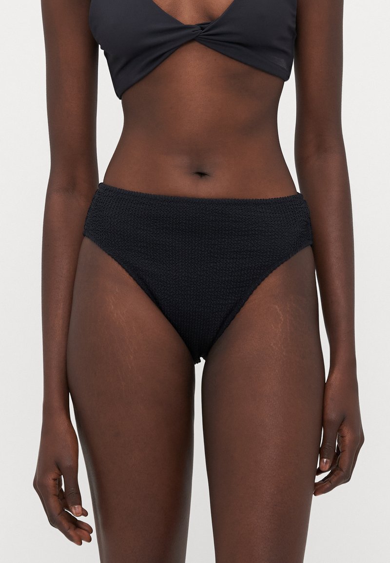 Bikini bottom nero a vita alta realizzato in tessuto testurizzato, con un motivo intrecciato e una vita elastica per una vestibilità confortevole.