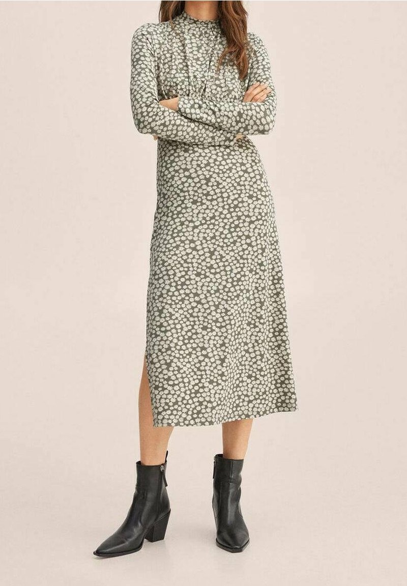 Grünes Blumenkleid in Midi-Länge mit langen Ärmeln, floralem Muster, seitlichem Schlitz, kombiniert mit schwarzen Knöchelstiefeln mit Blockabsatz.