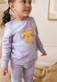 Pyjama en coton violet clair avec un appliqué visage d'ours sur le haut, agrémenté d'accents rose tendre et d'un pantalon à motif de nuages.