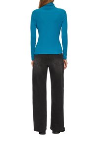 Turquoise lange mouwen turtleneck top gecombineerd met wijde zwarte broek, met achterzakken en een gladde textuur.