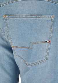 Light blue denim jeans with a single back pocket. The pocket features contrasting stitching and a small embroidered detail in red, white, and blue.