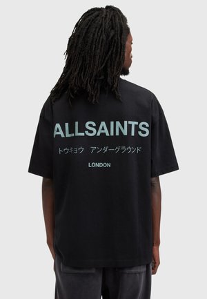 Camiseta de algodón negra con el texto "ALLSAINTS" en grandes letras azul claro, con caracteres japoneses y "LONDON" en la parte inferior.