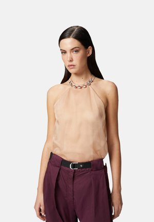 Top beige trasparente con scollatura halter, colletto decorato con dettagli argentati. Abbinato a pantaloni a vita alta bordeaux.
