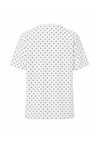 Camiseta blanca de mangas cortas con un patrón de lunares negros, cuello redondo y ajuste relajado. Tela de algodón suave.