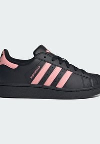 Μαύρα δερμάτινα αθλητικά παπούτσια με ροζ αρωματικές ρίγες και σήμα, καουτσούκ σόλα, στρογγυλή μύτη και λεπτομέρειες διάτρησης για αναπνευσιμότητα.