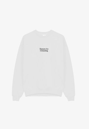Witte sweater met ronde hals en zwarte tekst gecentreerd op de borst met de tekst "Humans Are Exhausting."